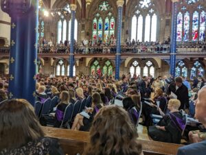 A room full of people in doctoral robes