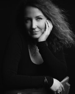 A black and white photo of a woman sitting on a chair