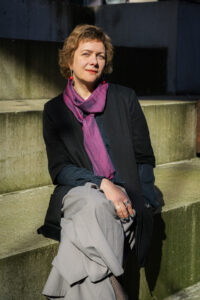 A woman wearing a purple scarf and a black jacket